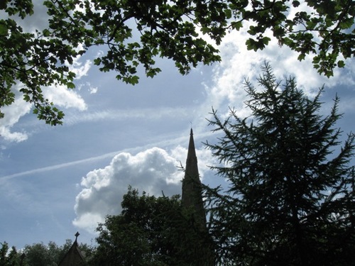 木々の間から教会の塔が見え　空にか飛行機雲のいたずら書き.jpg